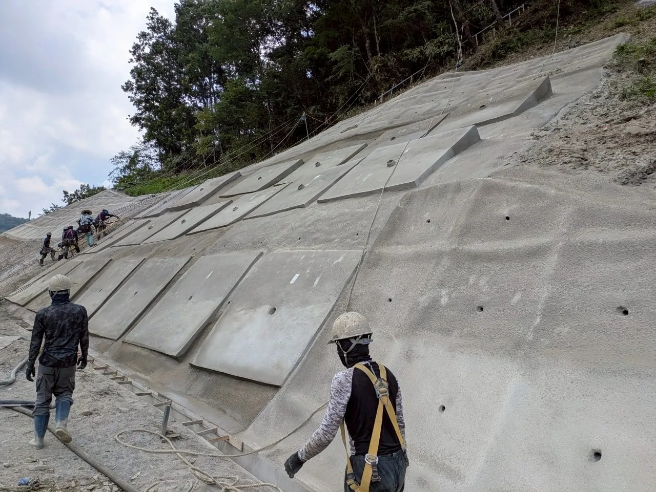 ⑥施工完了状況。法枠とモルタル吹付により安定した法面へ。